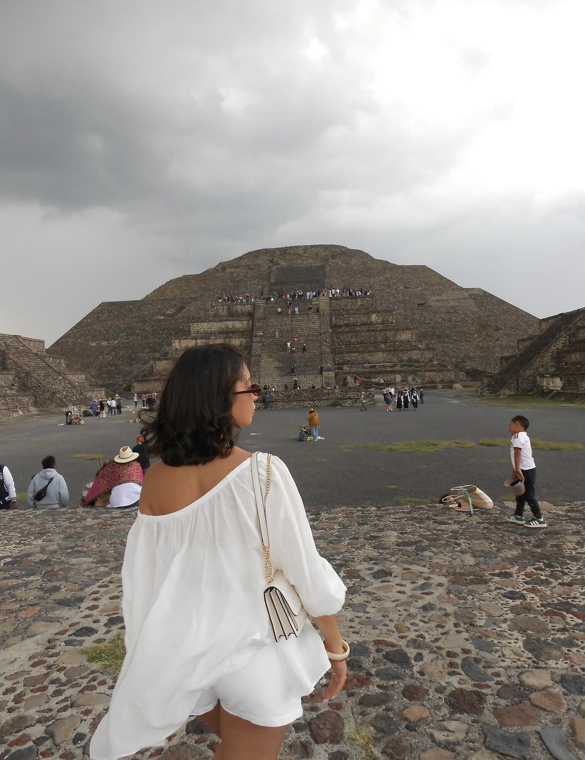Friendly local guide explaining Mayan carvings to tourists at the Ball Court in the archaeological zone